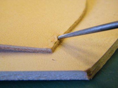 Awling side panel during workshop at The Falconry School