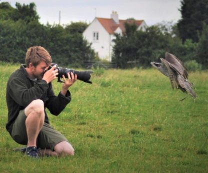 boy with photo camera photographing a falcon at The Falconry School